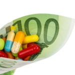 Tabletten und einhundert Eurogeldschein Symbolfoto: Kosten für Medizin und Medikamente der Pharmaindustrie