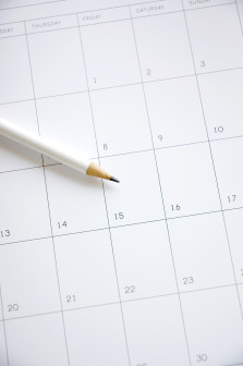 white pencil point to date fifteen on blank calendar
